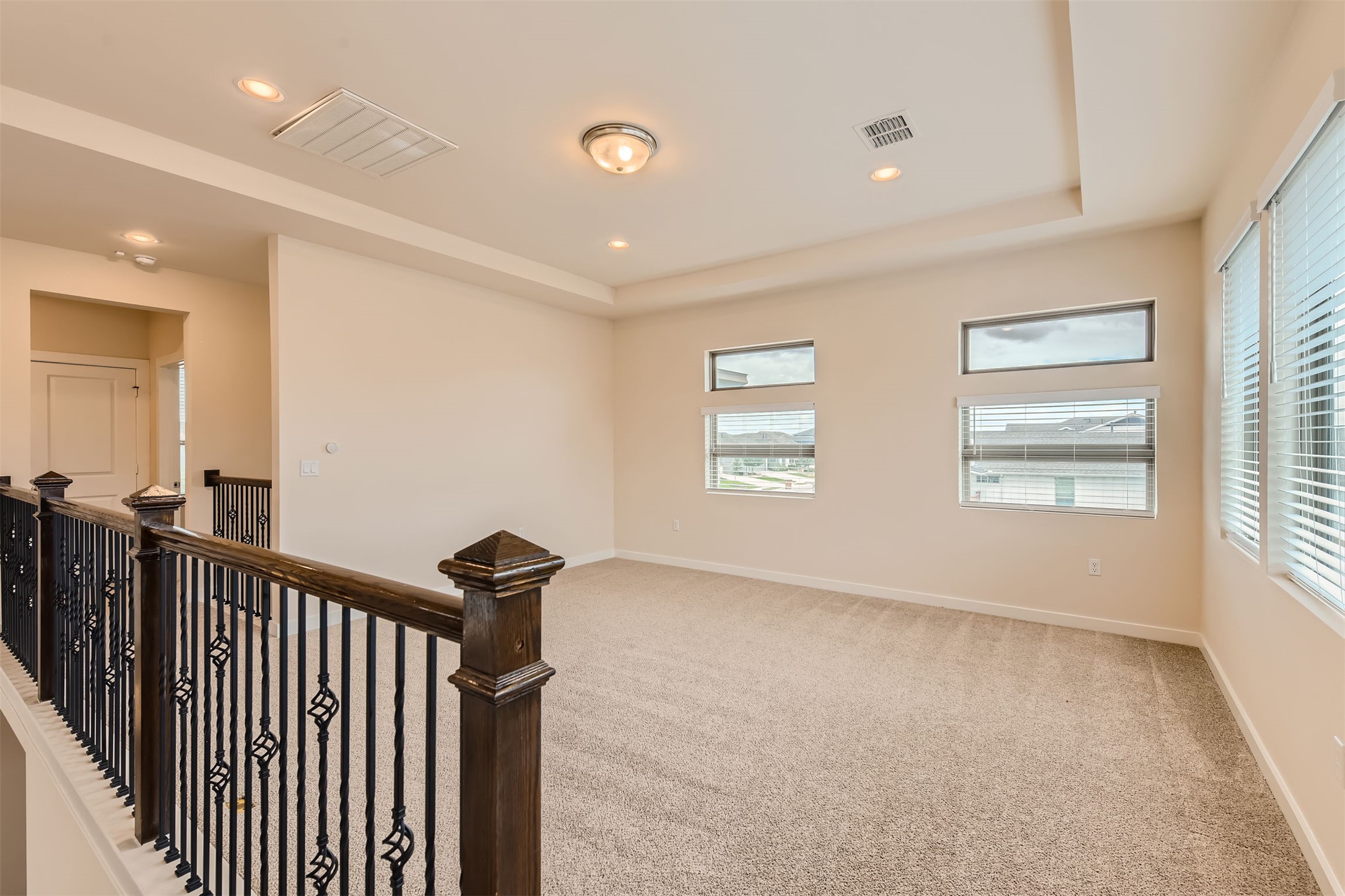 8313 Spire View Austin, TX 78744 - Photo 24 of 33 A versatile upstairs loft with plush carpeting and natural illumination from multiple windows.