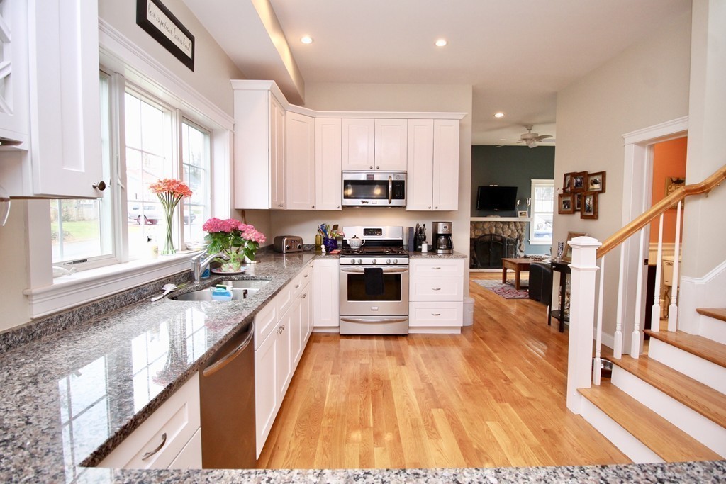 135 Argyle Road Braintree, MA 02184 - Photo 14 of 29 a kitchen with stainless steel appliances granite countertop a stove a sink and white cabinets with wooden floor