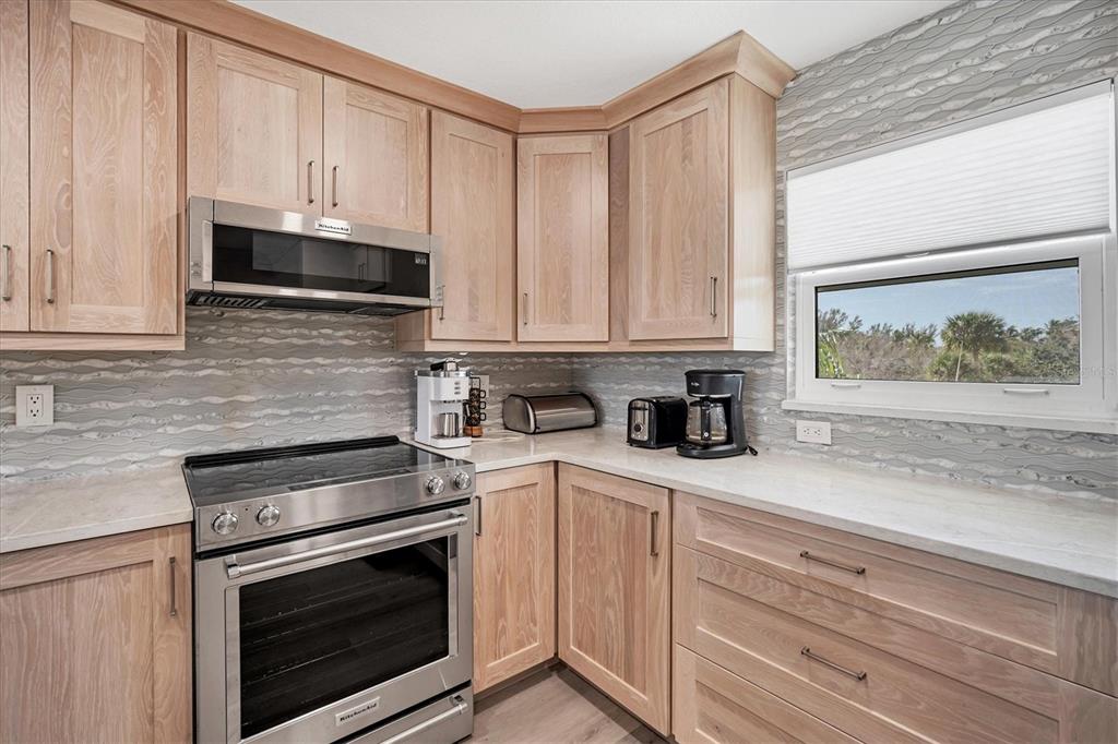 9393 Midnight Pass Road, Unit 302 Sarasota, FL 34242 - Photo 11 of 65 a kitchen with granite countertop white cabinets stainless steel appliances and sink
