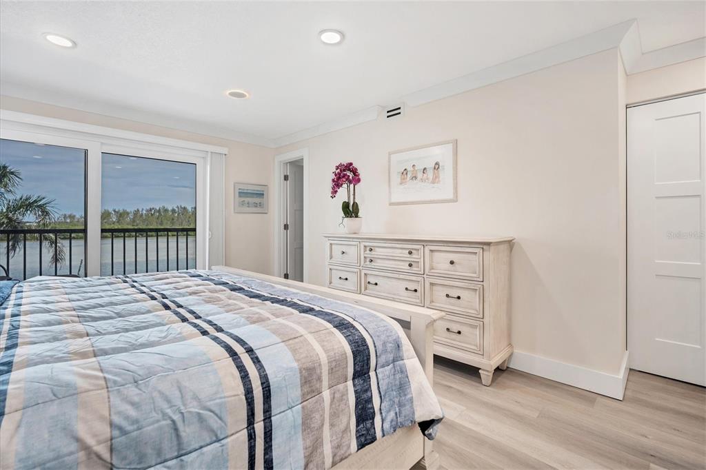 9393 Midnight Pass Road, Unit 302 Sarasota, FL 34242 - Photo 16 of 65 a bedroom with a bed a dresser and a large window