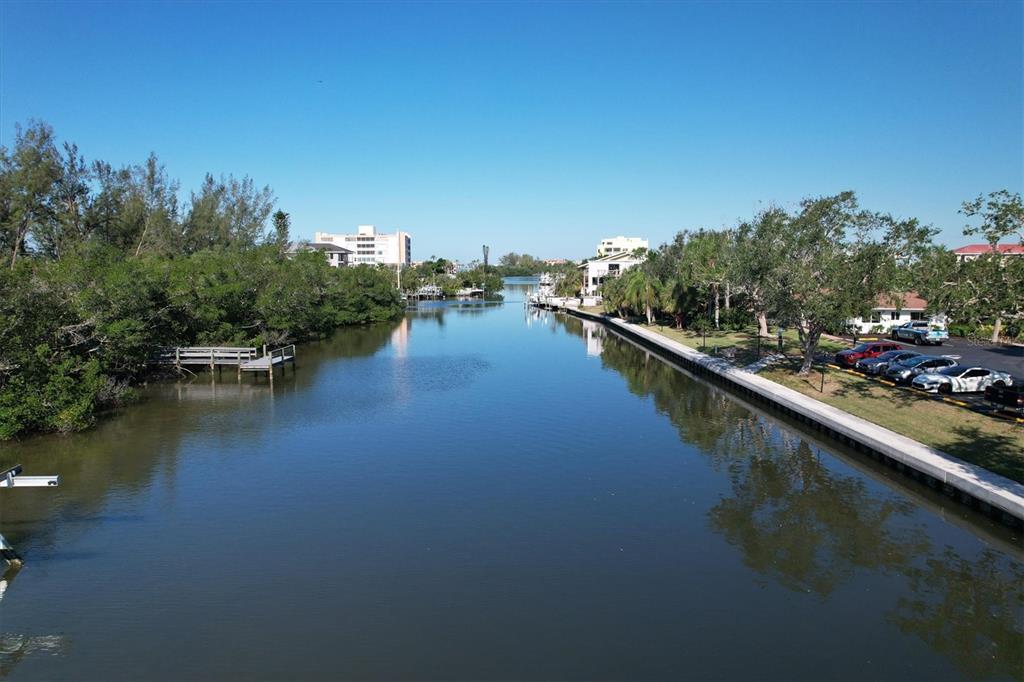 9393 Midnight Pass Road, Unit 302 Sarasota, FL 34242 - Photo 37 of 65 a view of a lake with boats and trees in the background