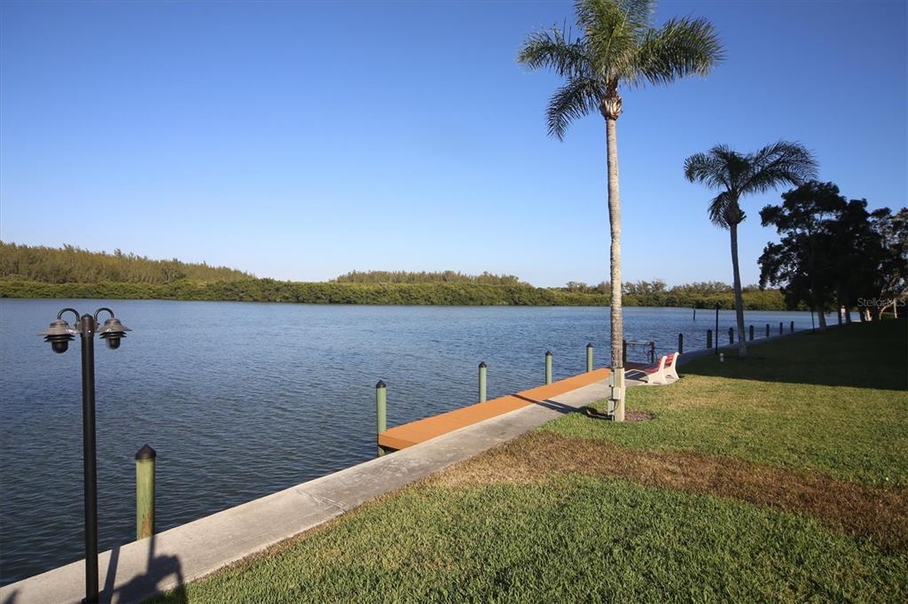 9393 Midnight Pass Road, Unit 302 Sarasota, FL 34242 - Photo 49 of 65 a view of a lake with a table and chairs