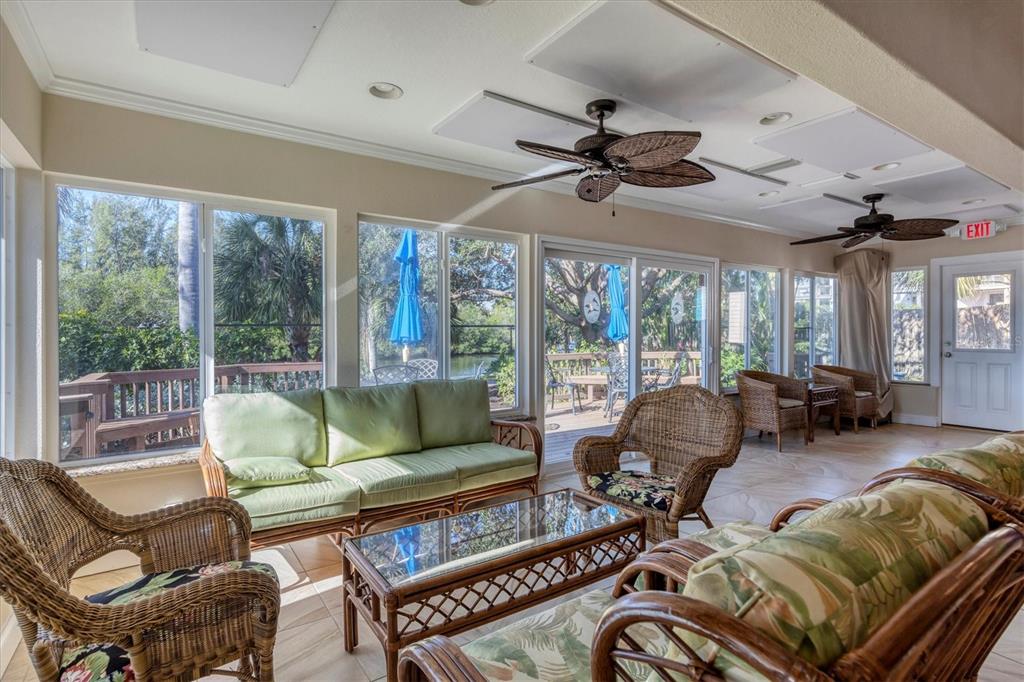 9393 Midnight Pass Road, Unit 302 Sarasota, FL 34242 - Photo 54 of 65 a living room with furniture ceiling fan and a large window