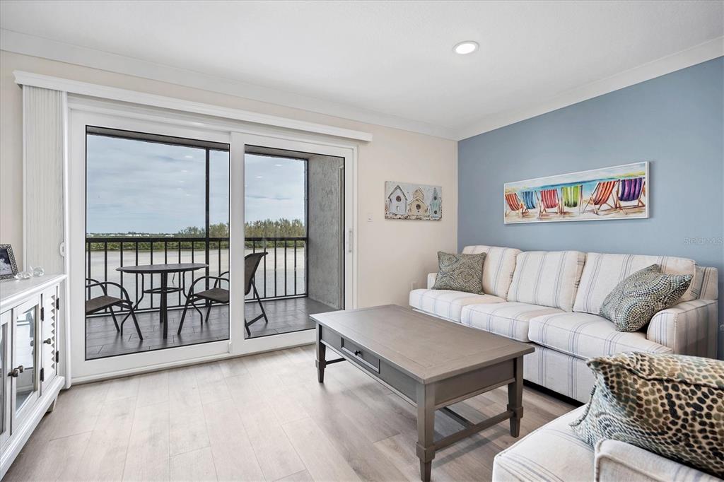 9393 Midnight Pass Road, Unit 302 Sarasota, FL 34242 - Photo 6 of 65 a living room with furniture a table and a large window