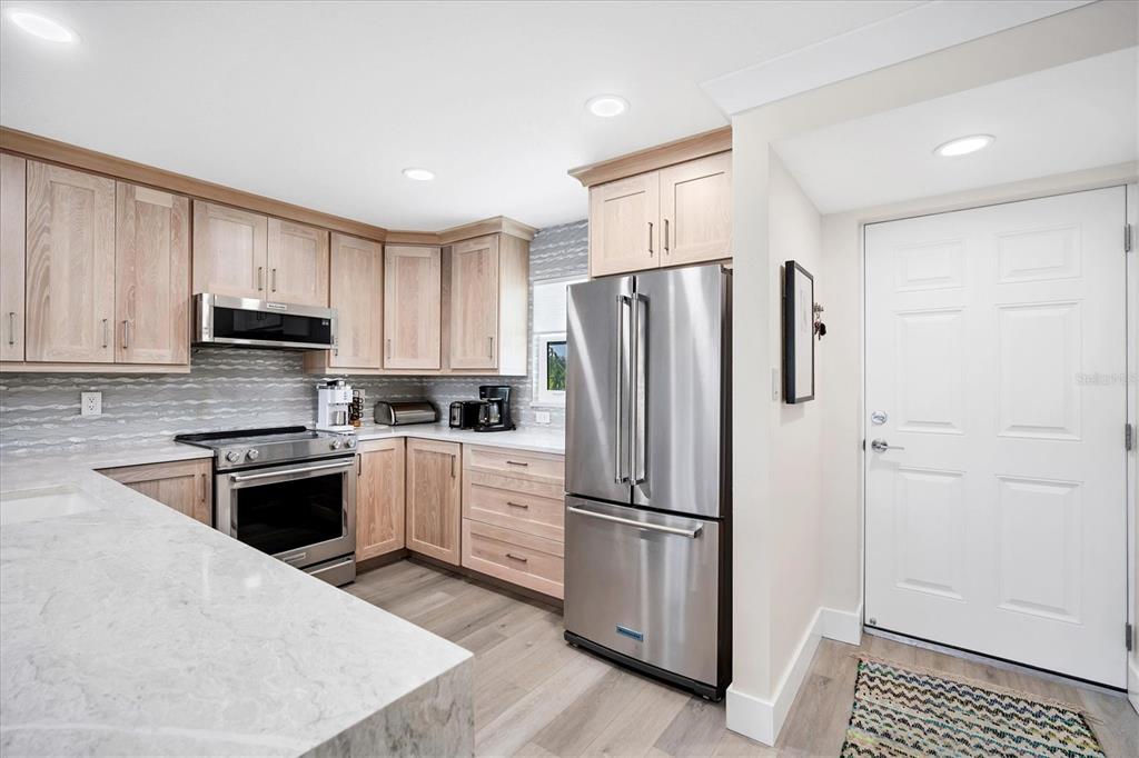 9393 Midnight Pass Road, Unit 302 Sarasota, FL 34242 - Photo 9 of 65 a kitchen with granite countertop cabinets and steel stainless steel appliances