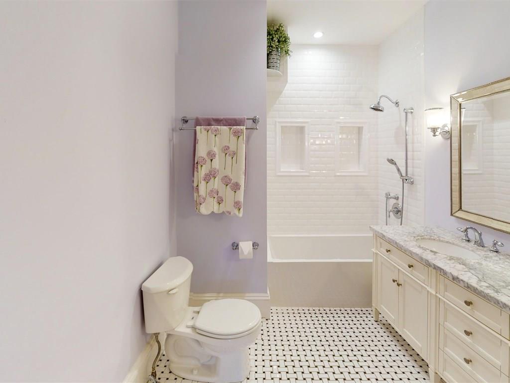 6 Kennard Road Brookline, MA 02445 - Photo 23 of 39 a bathroom with a granite countertop toilet a sink a mirror a bathtub and shower