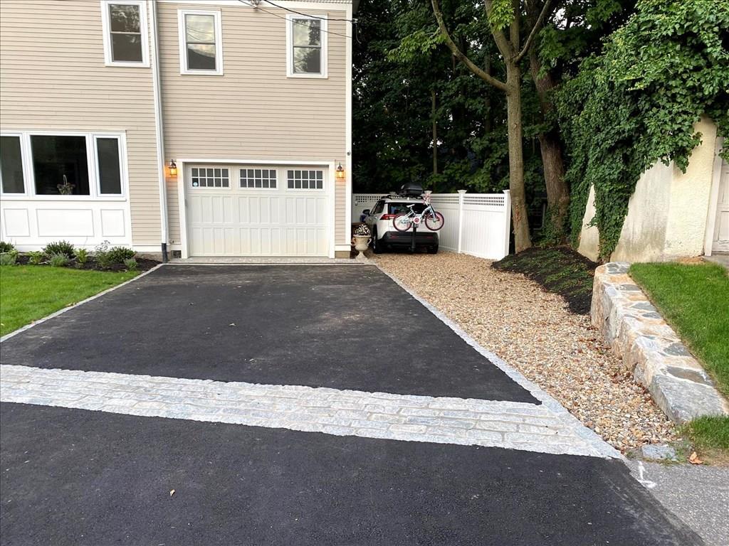 6 Kennard Road Brookline, MA 02445 - Photo 36 of 39 a front view of a house with a yard and garage