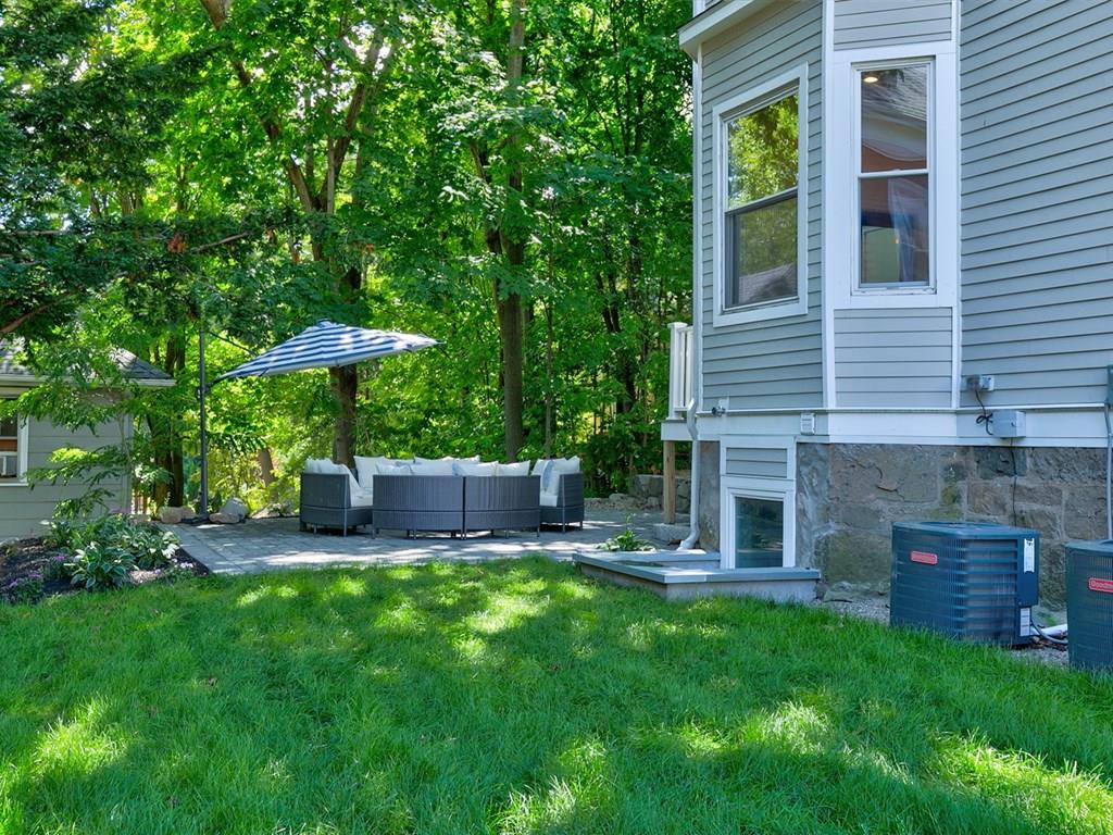 6 Kennard Road Brookline, MA 02445 - Photo 5 of 39 a view of a chair and table under an umbrella in the backyard