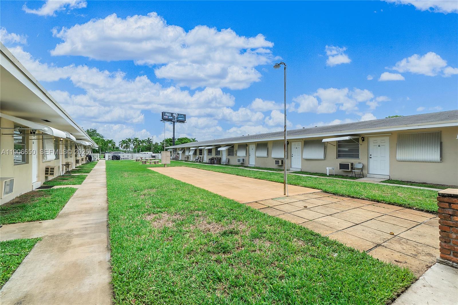 2901 Polk Street, Unit 14 Hollywood, FL 33020 - Photo 16 of 16 a view of an house with backyard and a tree