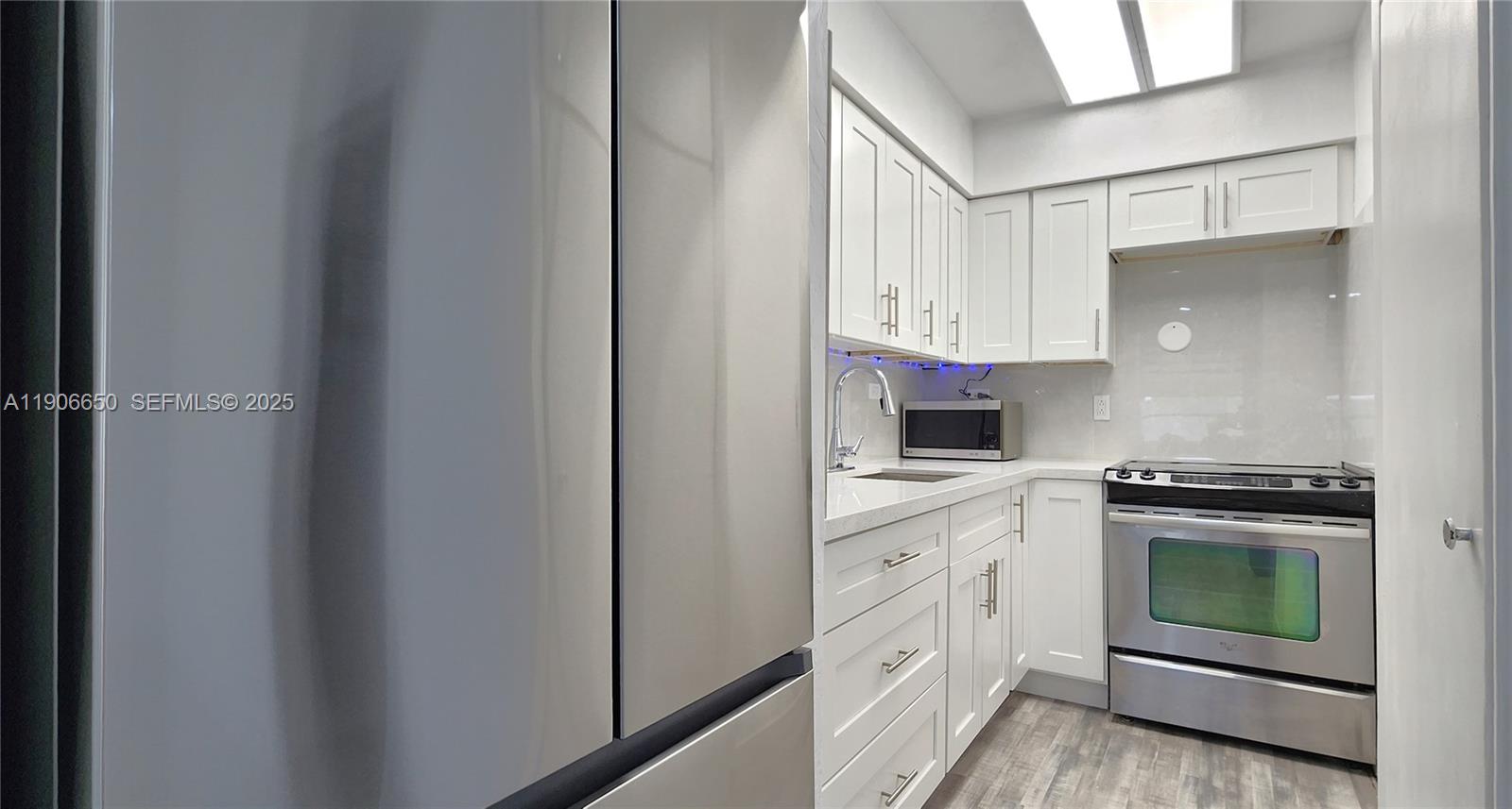 2901 Polk Street, Unit 14 Hollywood, FL 33020 - Photo 6 of 16 a kitchen with white cabinets and appliances