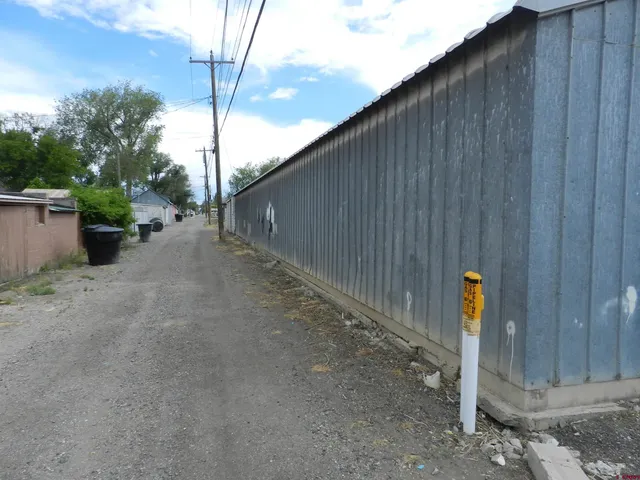 a view of a dry yard with wooden fence