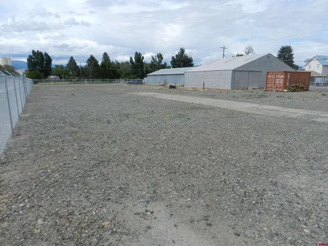 a view of a dry yard with wooden fence