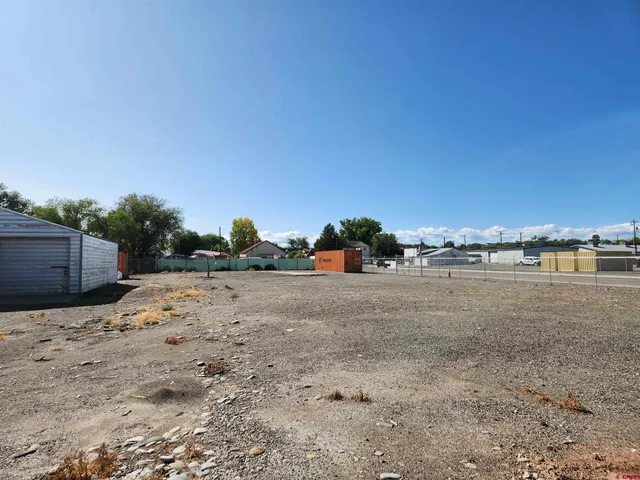 a view of a dry yard with wooden fence