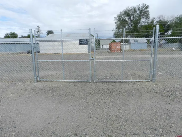 a view of a dry yard with wooden fence