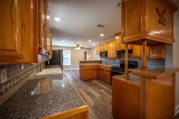 a kitchen with stainless steel appliances granite countertop a stove a refrigerator and a oven