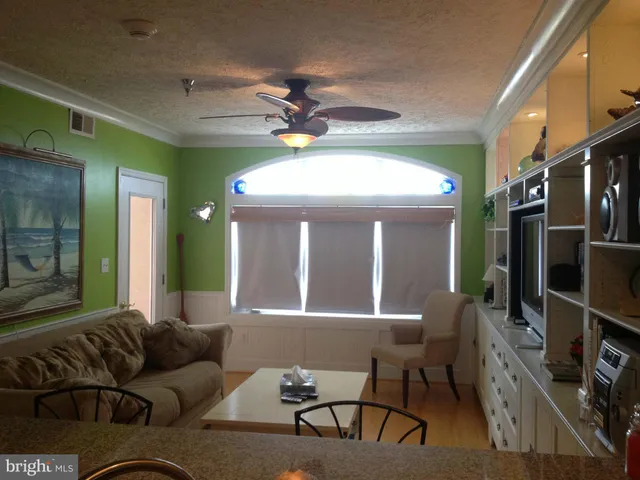 a living room with furniture a chandelier and a large window