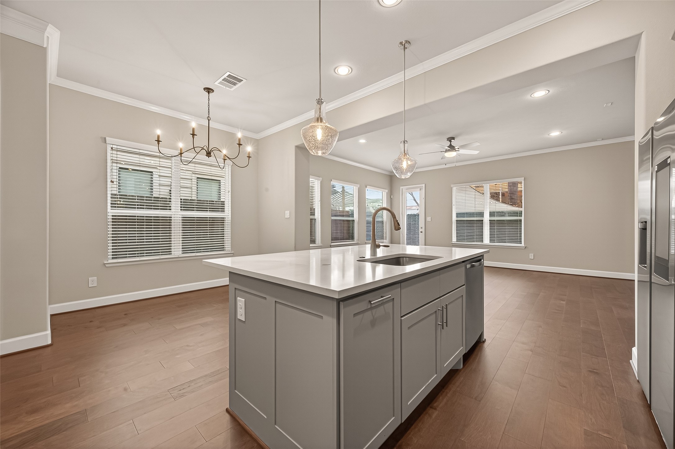 4413 Schuler Street, Unit B Houston, TX 77007 - Photo 19 of 46 a kitchen with granite countertop center island wooden floor and a chandelier