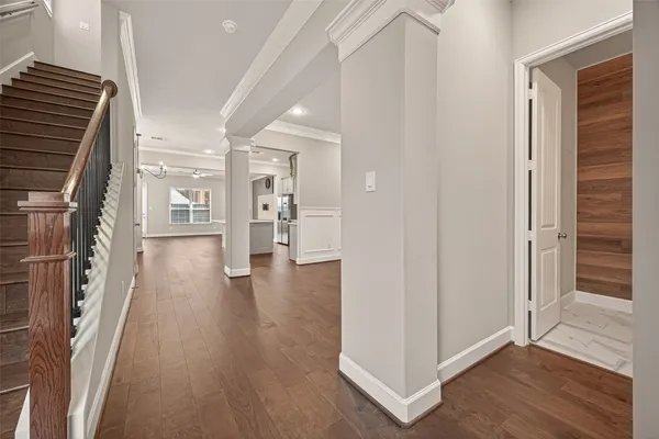 a view of an empty room with wooden floor and windows
