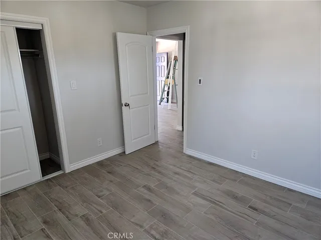 an empty room with wooden floor and closet