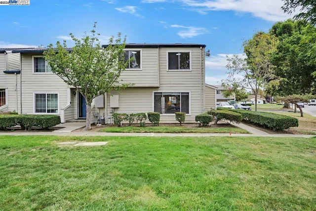 a view of a house with a big yard and large trees