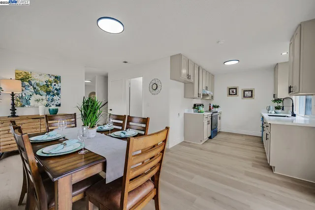 a kitchen with granite countertop a table chairs stove and cabinets