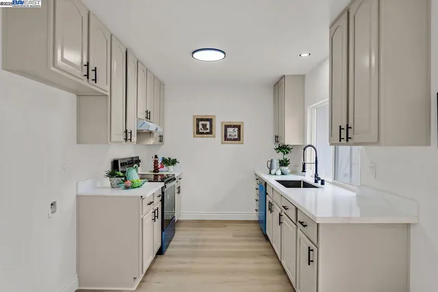 a kitchen with stainless steel appliances a sink stove and cabinets