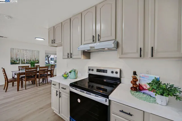 a kitchen with granite countertop cabinets stainless steel appliances and wooden floor