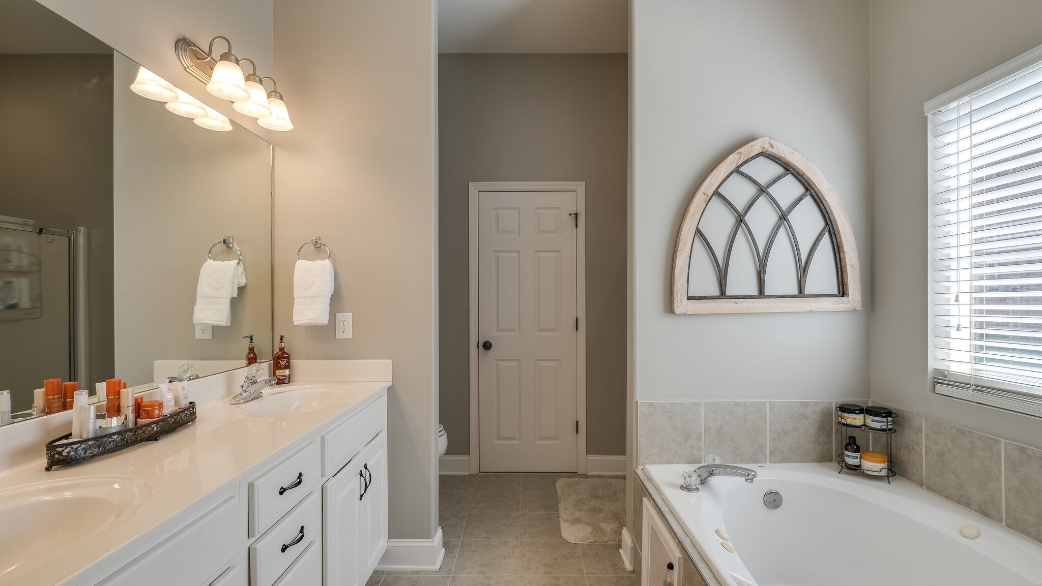 7005 Red Apple Road Antioch, TN 37013 - Photo 15 of 25 a bathroom with a double vanity sink mirror and a bathtub
