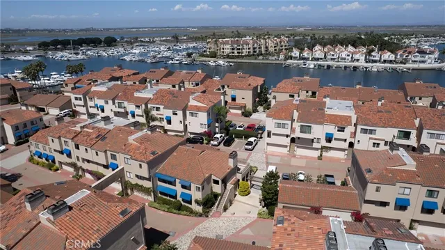 an aerial view of a city with lots of residential buildings and ocean view in back