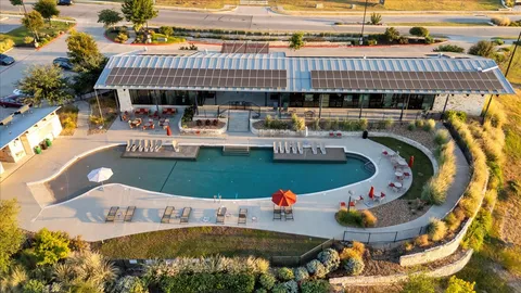 an aerial view of a house with swimming pool and outdoor seating