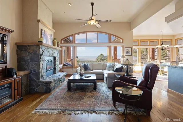 a living room with furniture a fireplace and a large window