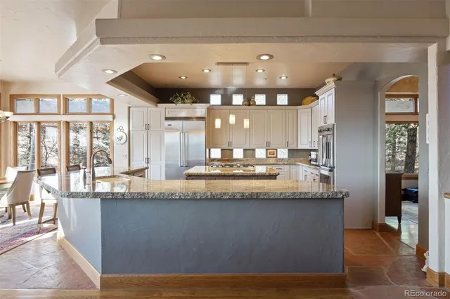 a large hall with stainless steel appliances granite countertop lots of counter top and stove