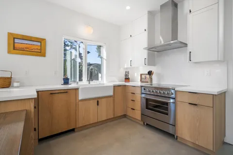 a kitchen with stainless steel appliances a dining table and chairs