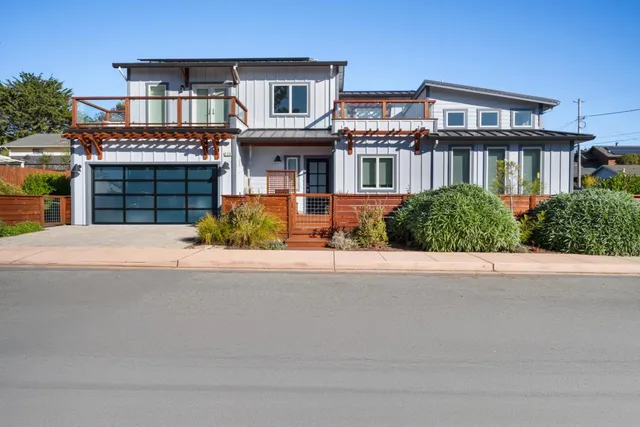 a front view of a house with yard and parking