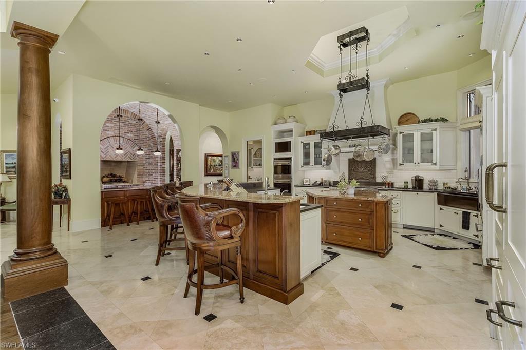 14928 Celle Way Naples, FL 34110 - Photo 19 of 35 a kitchen with stainless steel appliances kitchen island granite countertop a stove a sink and a refrigerator