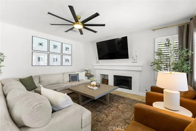 a living room with furniture a flat screen tv and a fireplace