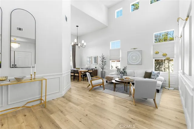 a living room with furniture a large window and wooden floor