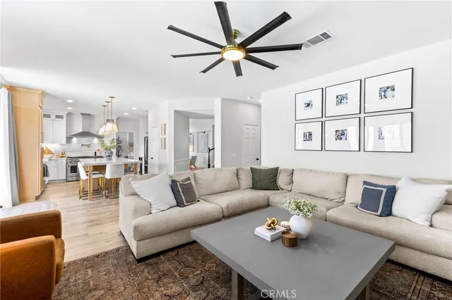 a living room with furniture kitchen view and a window