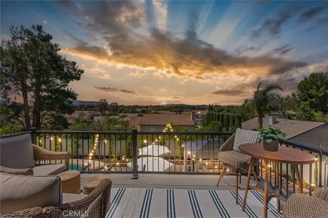 a balcony with wooden floor table and chairs