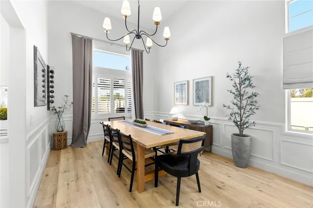 a dining room with wooden floor and chandelier