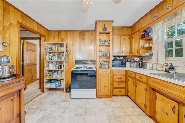 a view of living room kitchen with stainless steel appliances kitchen island granite countertop furniture and a large window