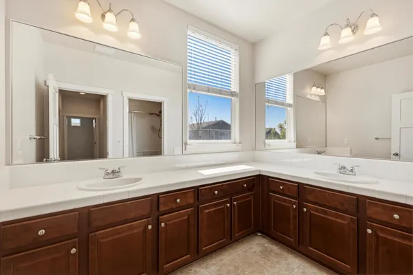 a bathroom with a double vanity sink mirror and shower