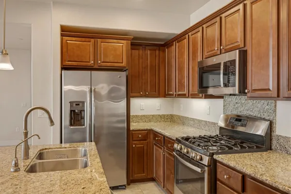 a kitchen with granite countertop stainless steel appliances and a counter space