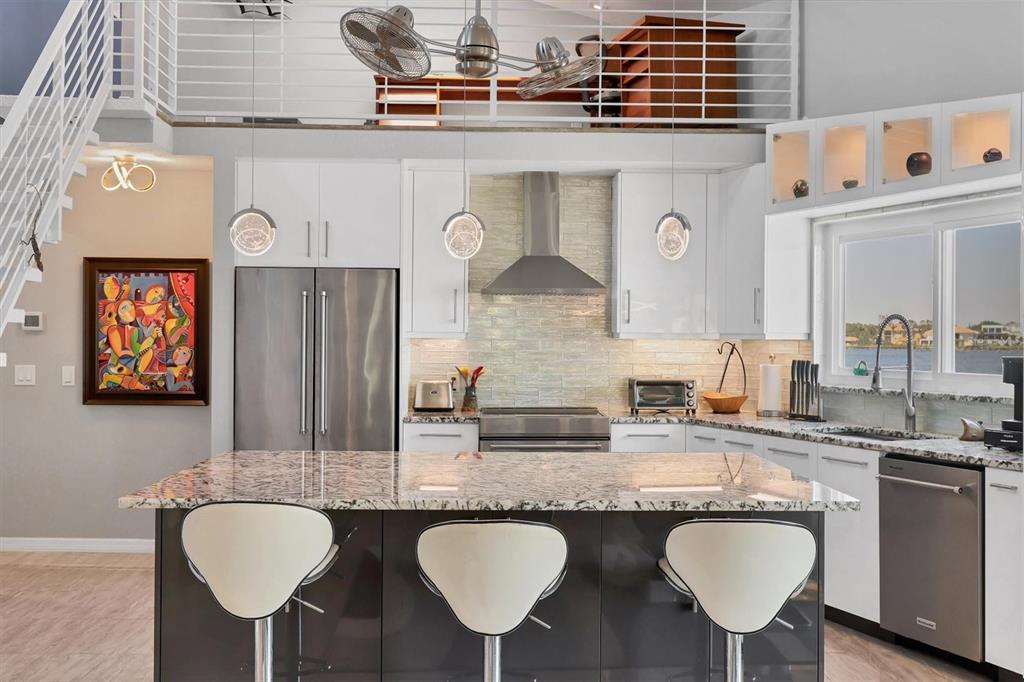 7985 Manasota Key Road Englewood, FL 34223 - Photo 14 of 83 a kitchen with stainless steel appliances granite countertop a sink and a refrigerator