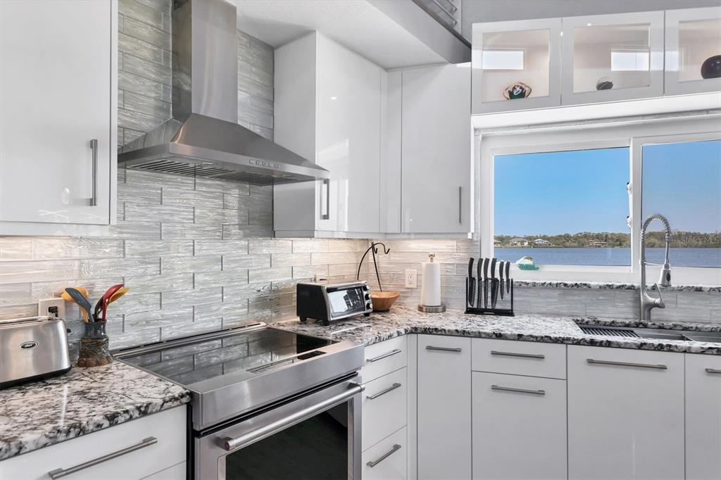 7985 Manasota Key Road Englewood, FL 34223 - Photo 17 of 83 a kitchen with stainless steel appliances granite countertop a sink stove and cabinets