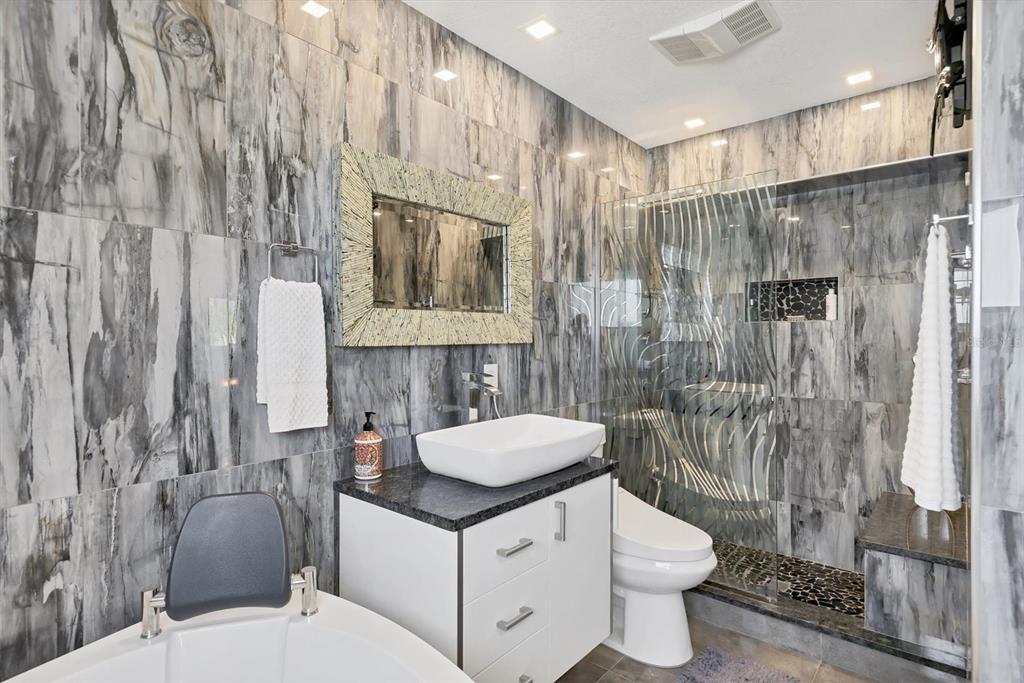 7985 Manasota Key Road Englewood, FL 34223 - Photo 30 of 83 a bathroom with a sink a toilet and shower