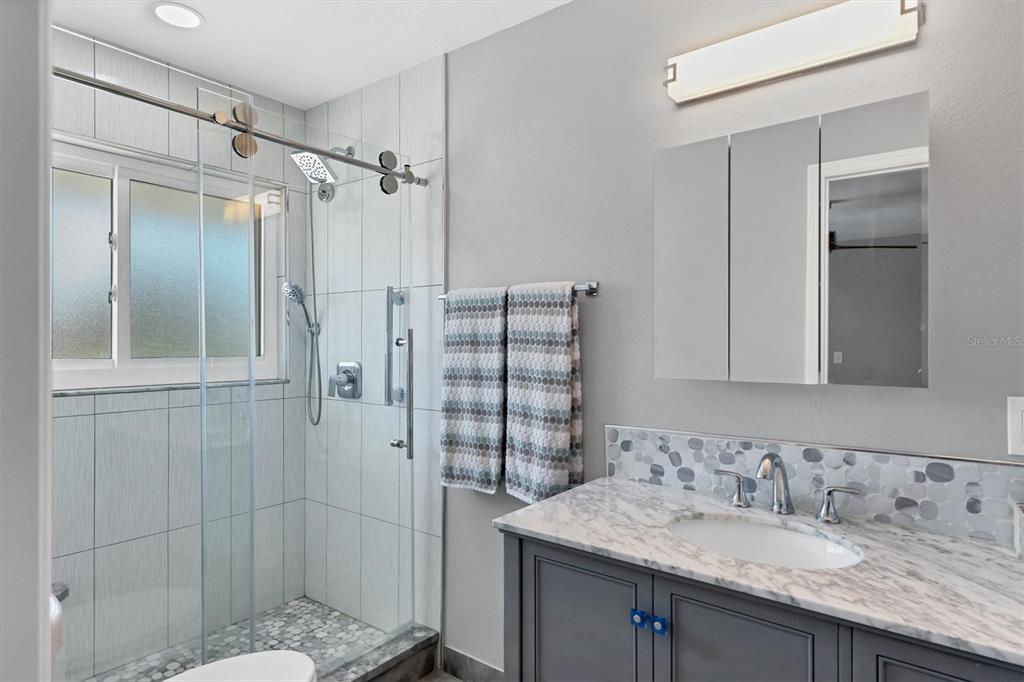 7985 Manasota Key Road Englewood, FL 34223 - Photo 34 of 83 a bathroom with a granite countertop sink and a mirror