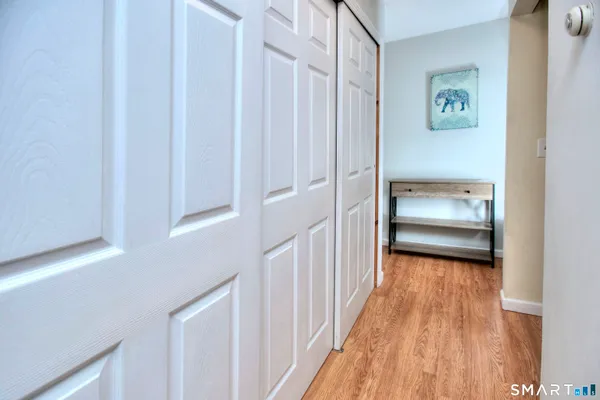 a view of a hallway with wooden floor and closet