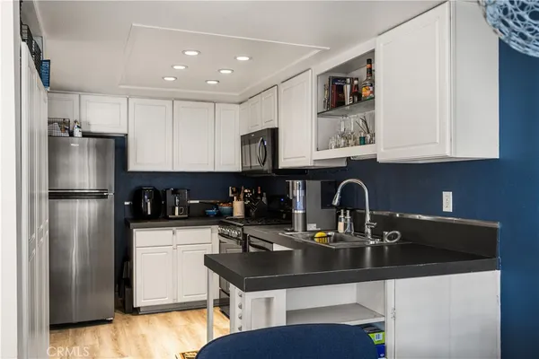 a kitchen with a sink a refrigerator and cabinets