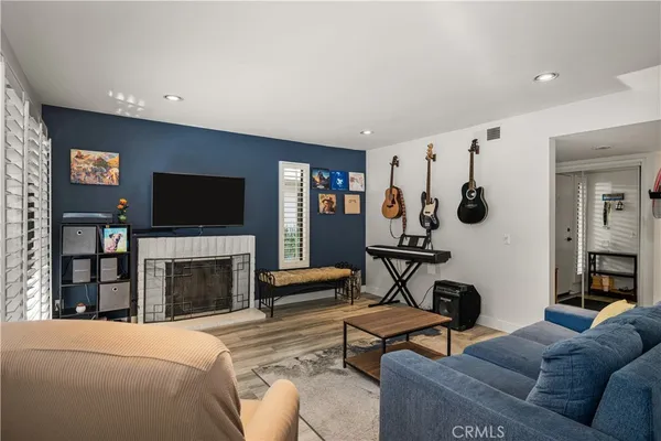 a living room with furniture a flat screen tv and a fireplace